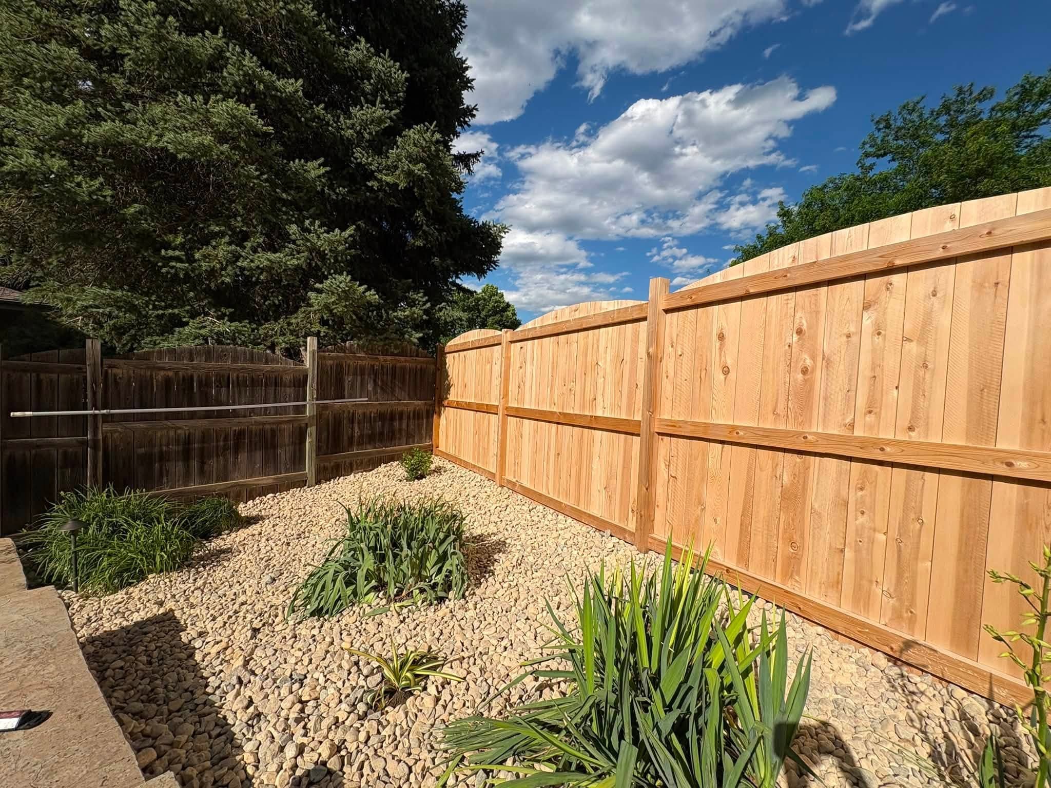 Rock planting bed along a fence