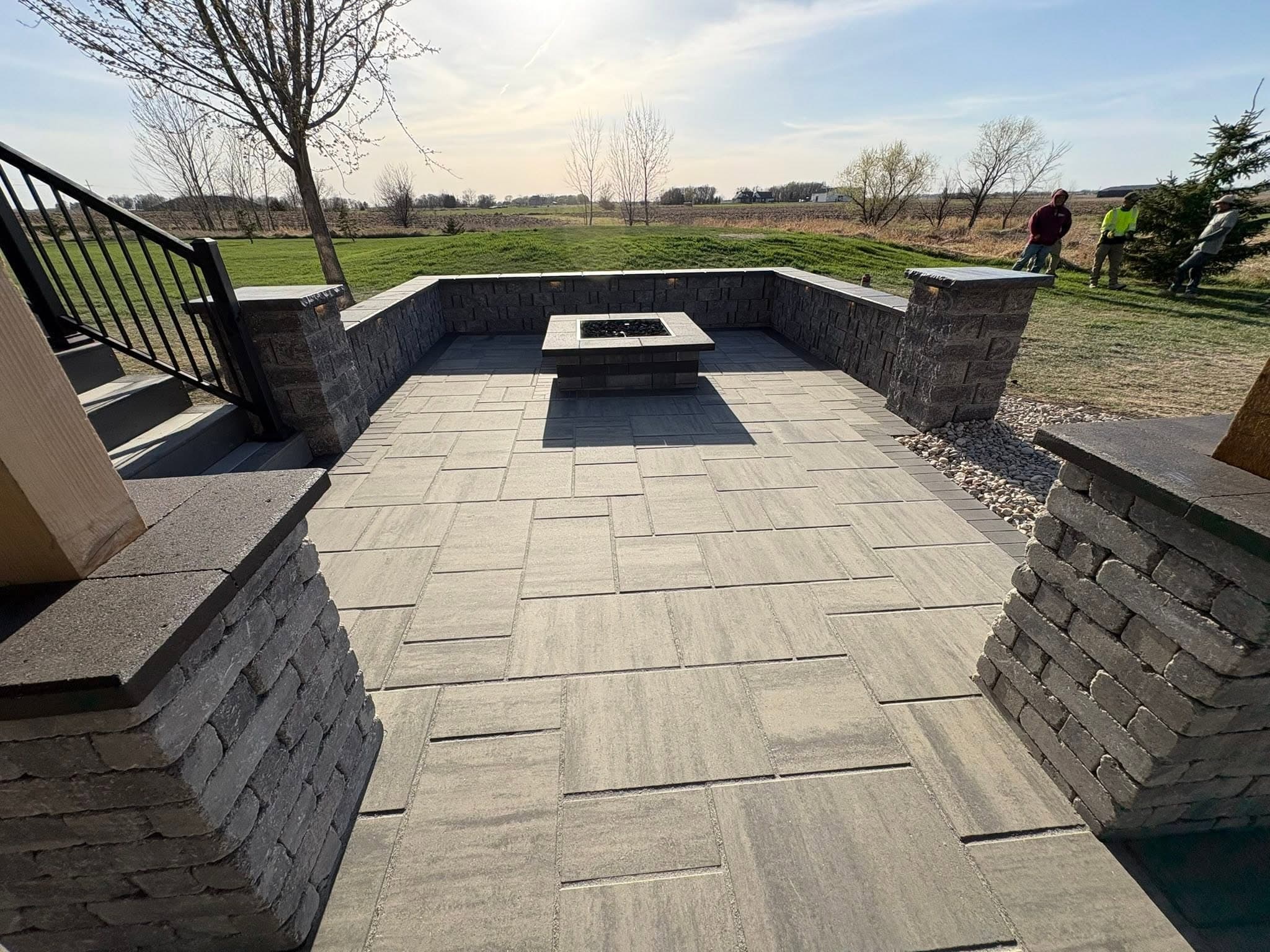 Wide view of a paver patio with seat walls and fire pit