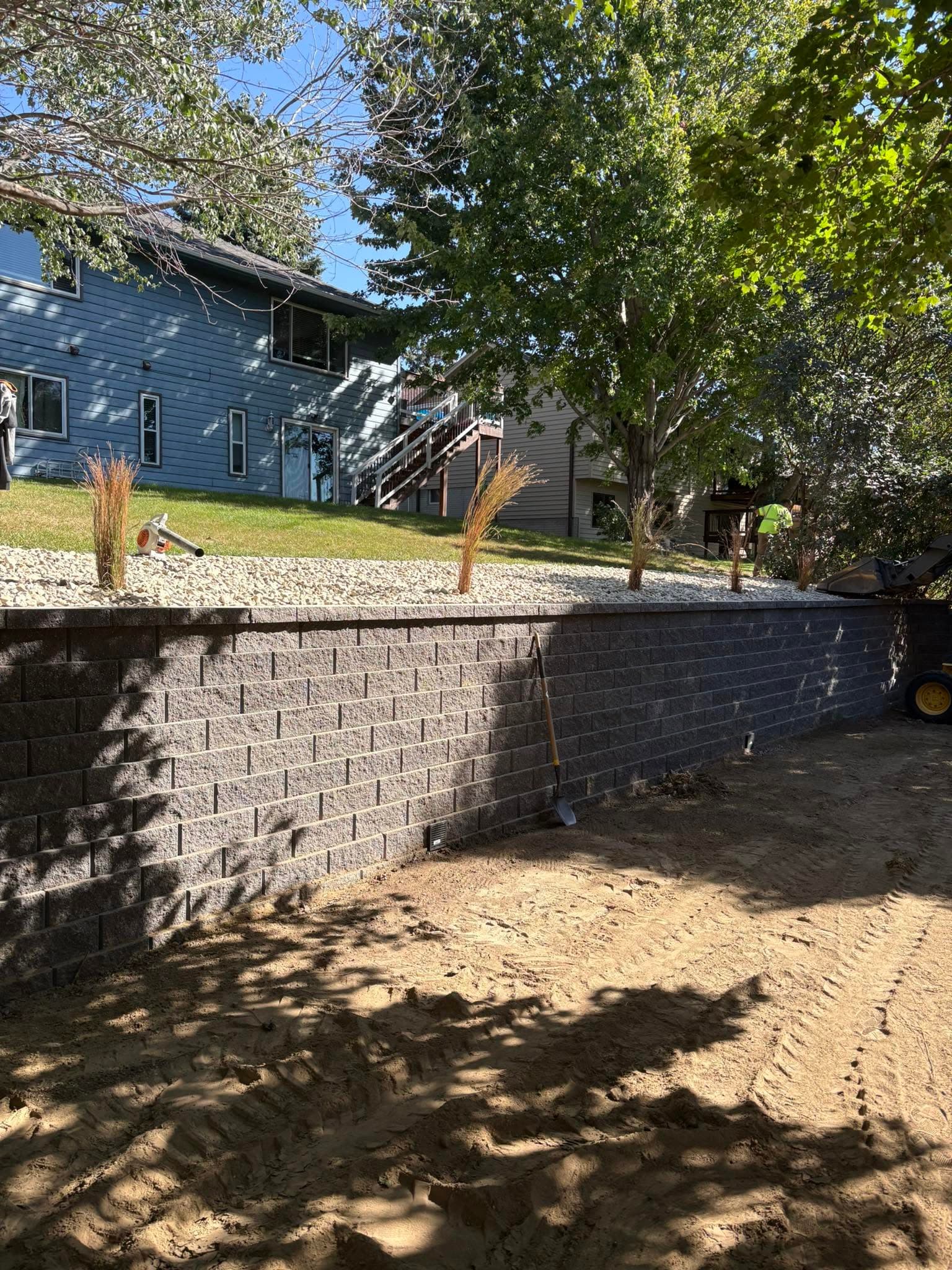 Freshly laid block retaining wall, sand and tools still below