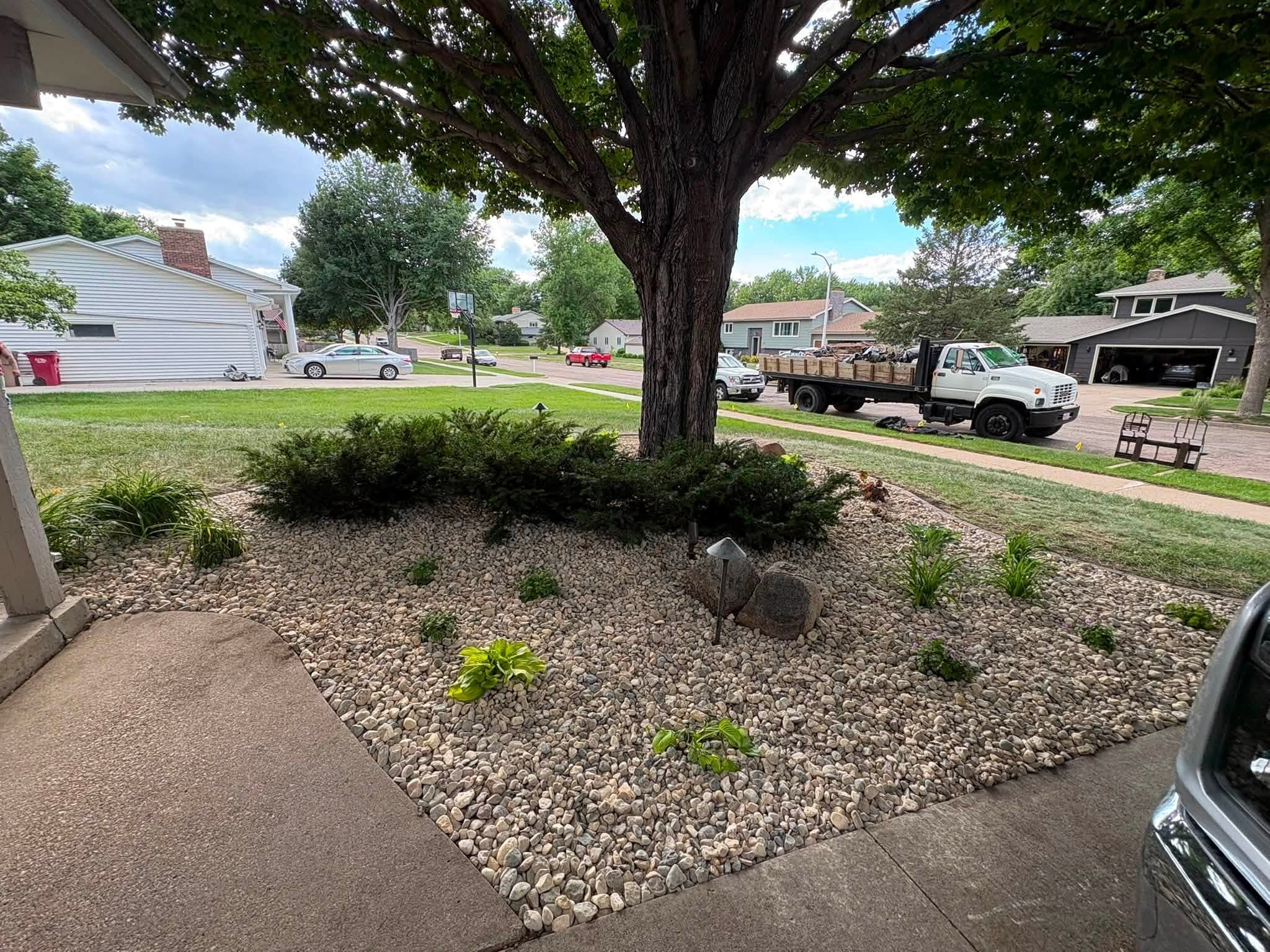 Rock bed around a tree by the driveway