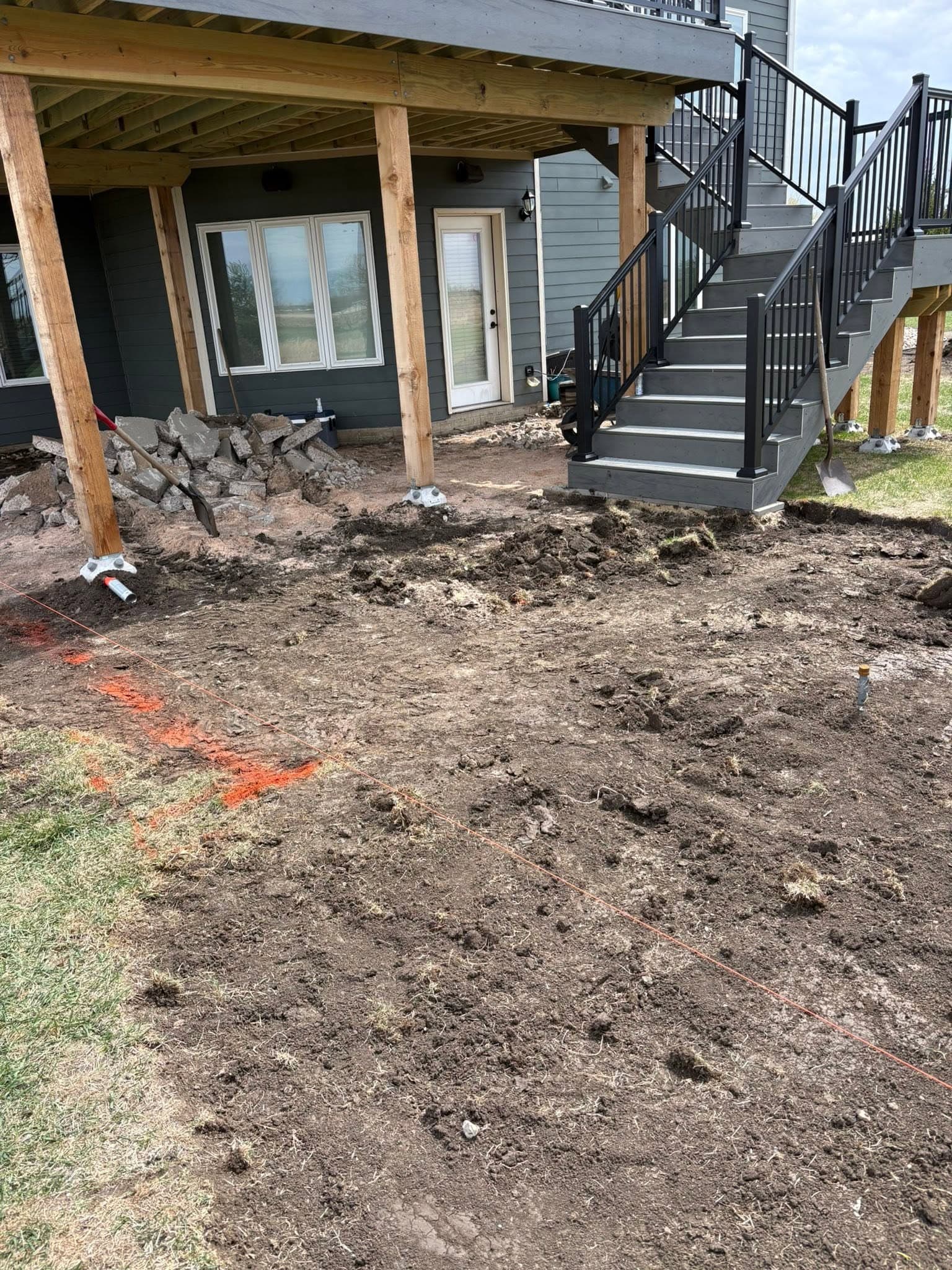 Ground opened up for a patio under new deck stairs