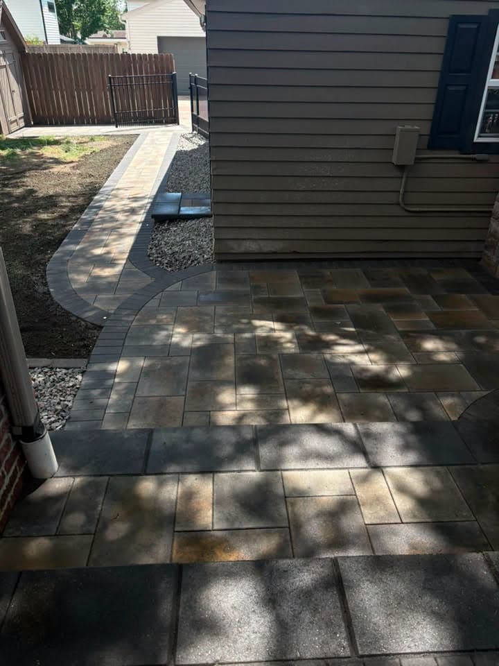 Dark paver walkway along a side yard