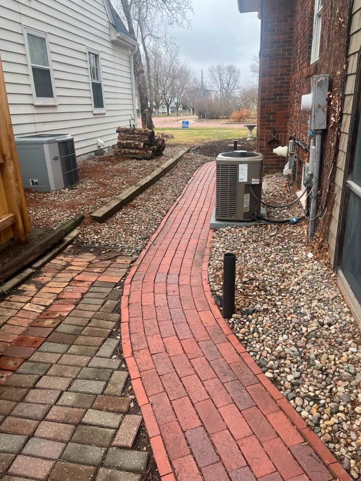 Red paver walkway lit by a path light bollard