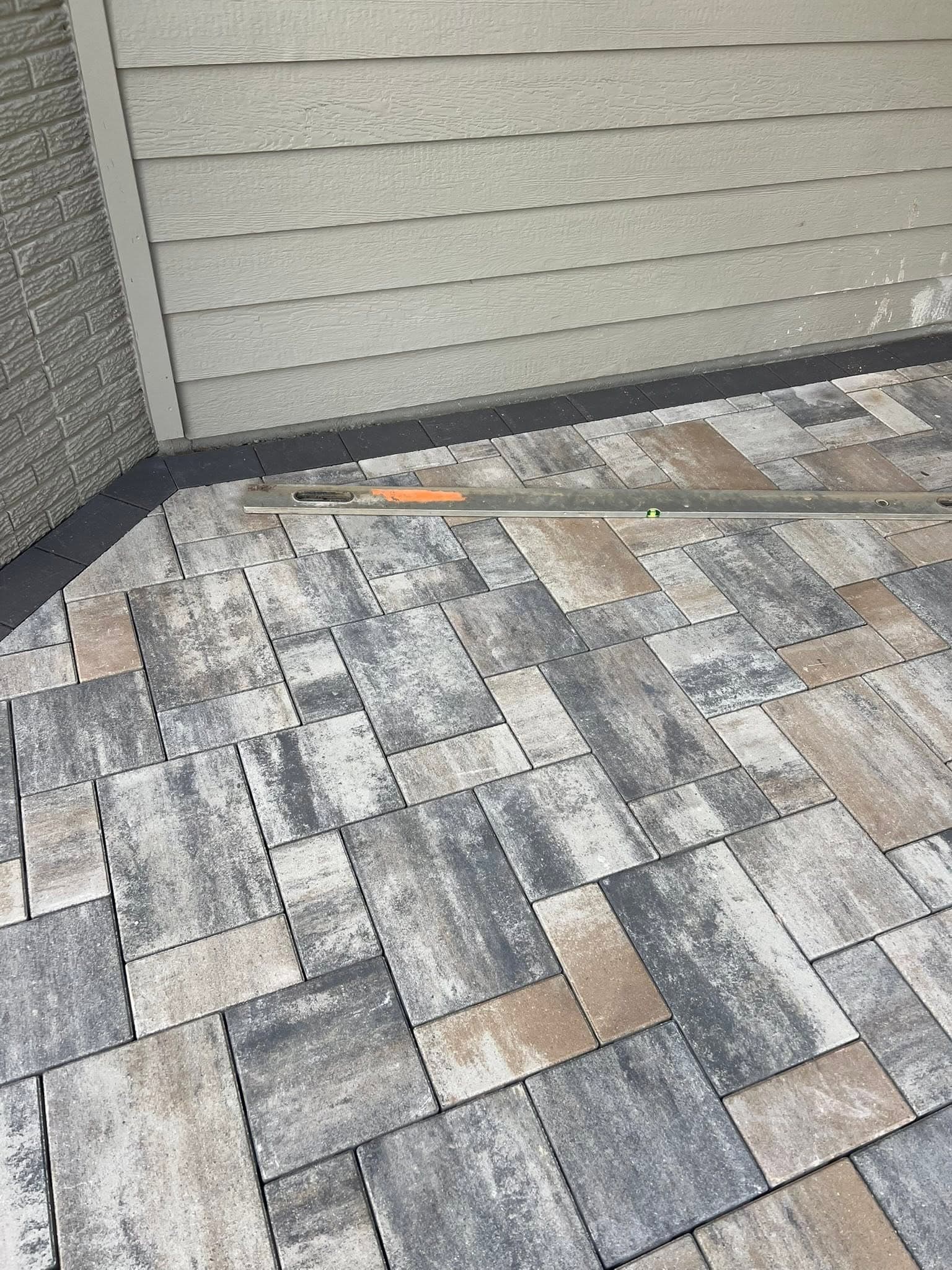 Plank paver patio up close, a level resting on the stone