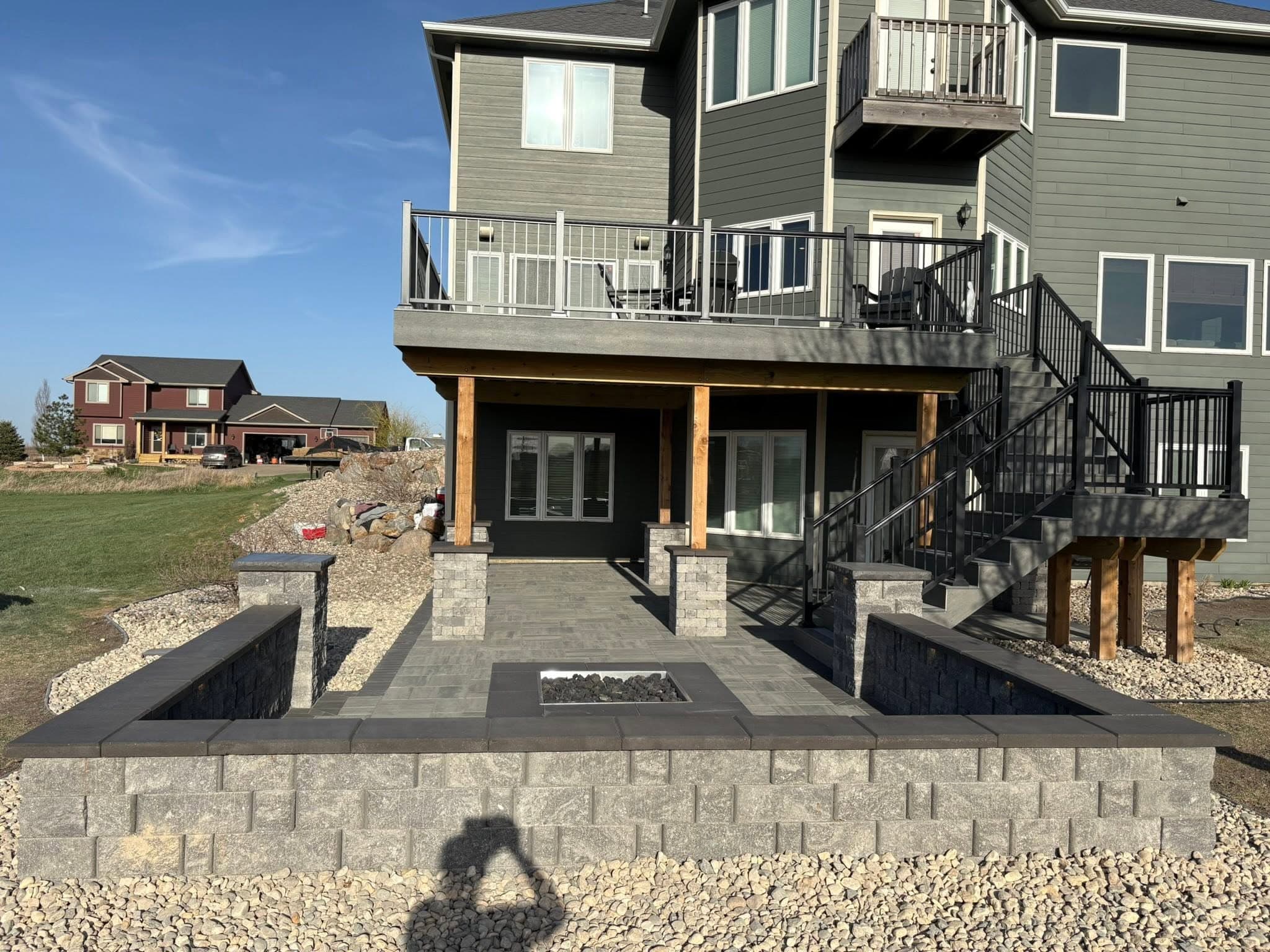 Tiered block retaining walls and steps framing a finished walkout patio
